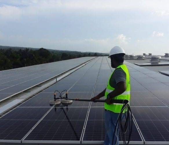 Technician cleaning a factory rooftop array in Kurunegala