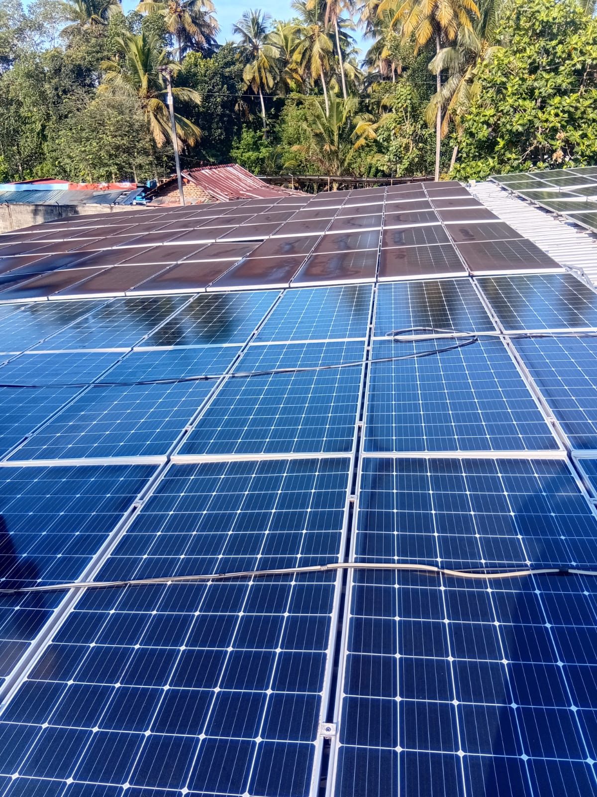 Rooftop array partially cleaned, residue still visible on far panels